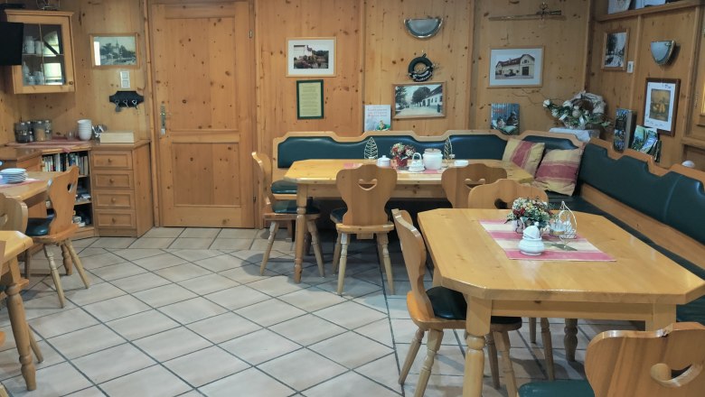 Gemütlicher Frühstücksraum mit Holzmöbeln und Dekorationen.