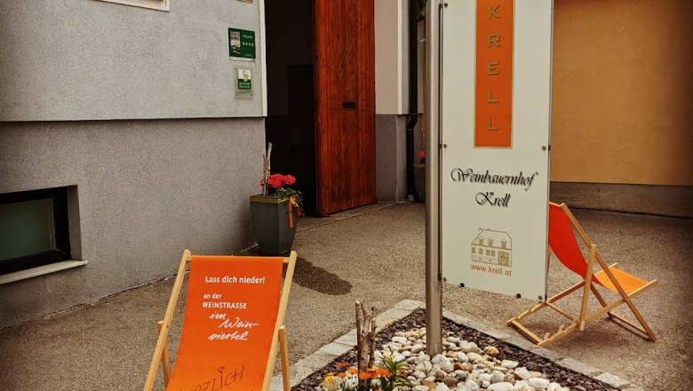 Eingang zum Weingut Krell mit Liegestühlen und Blumen.