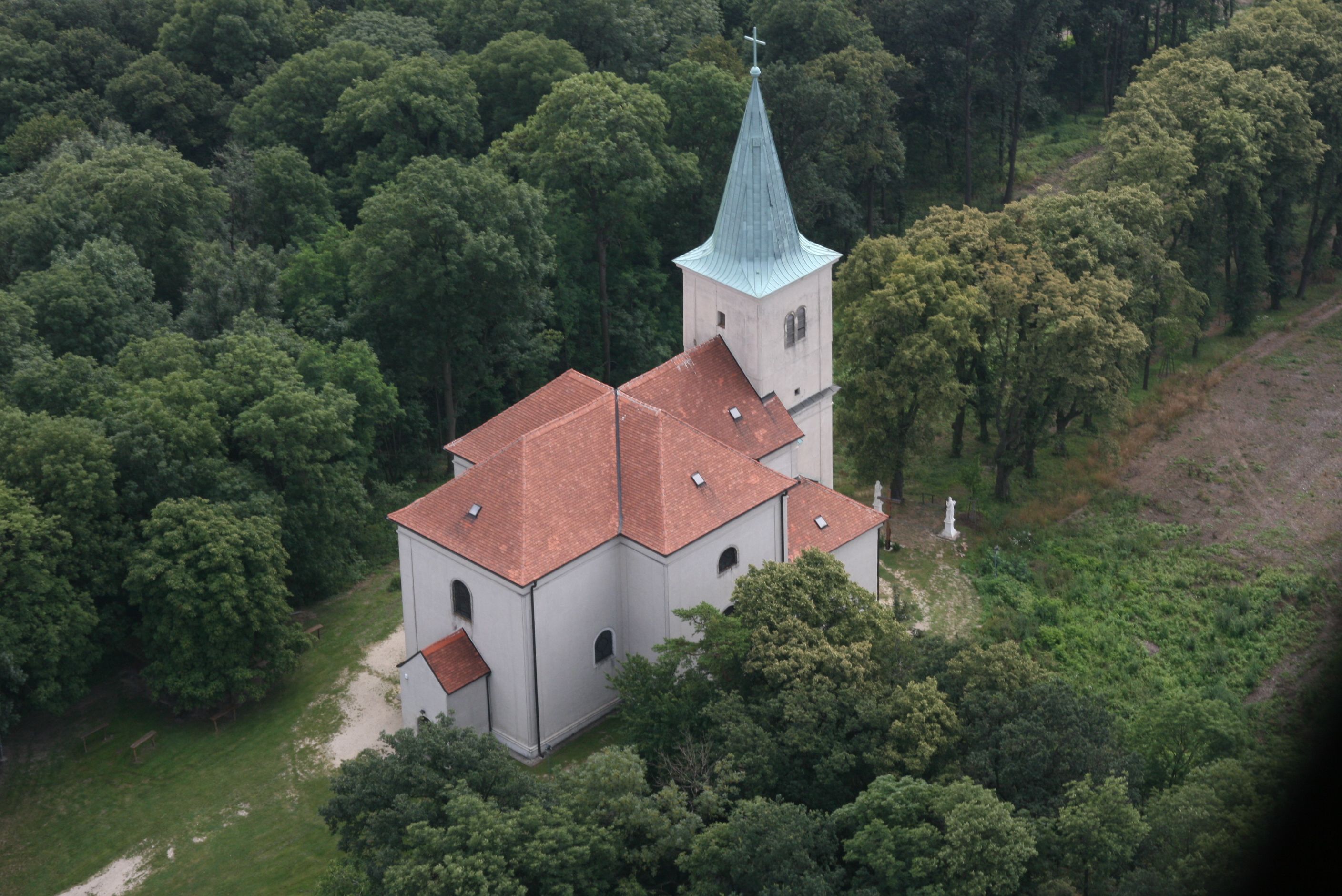 Luftaufnahme der Wallfahrtskirche Karnabrunn umgeben von Bäumen.