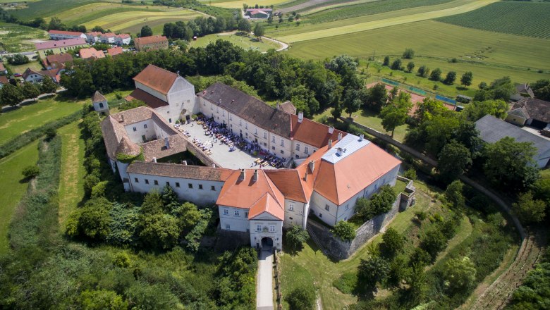 Luftaufnahme von Schloss Mailberg mit umliegender Landschaft.