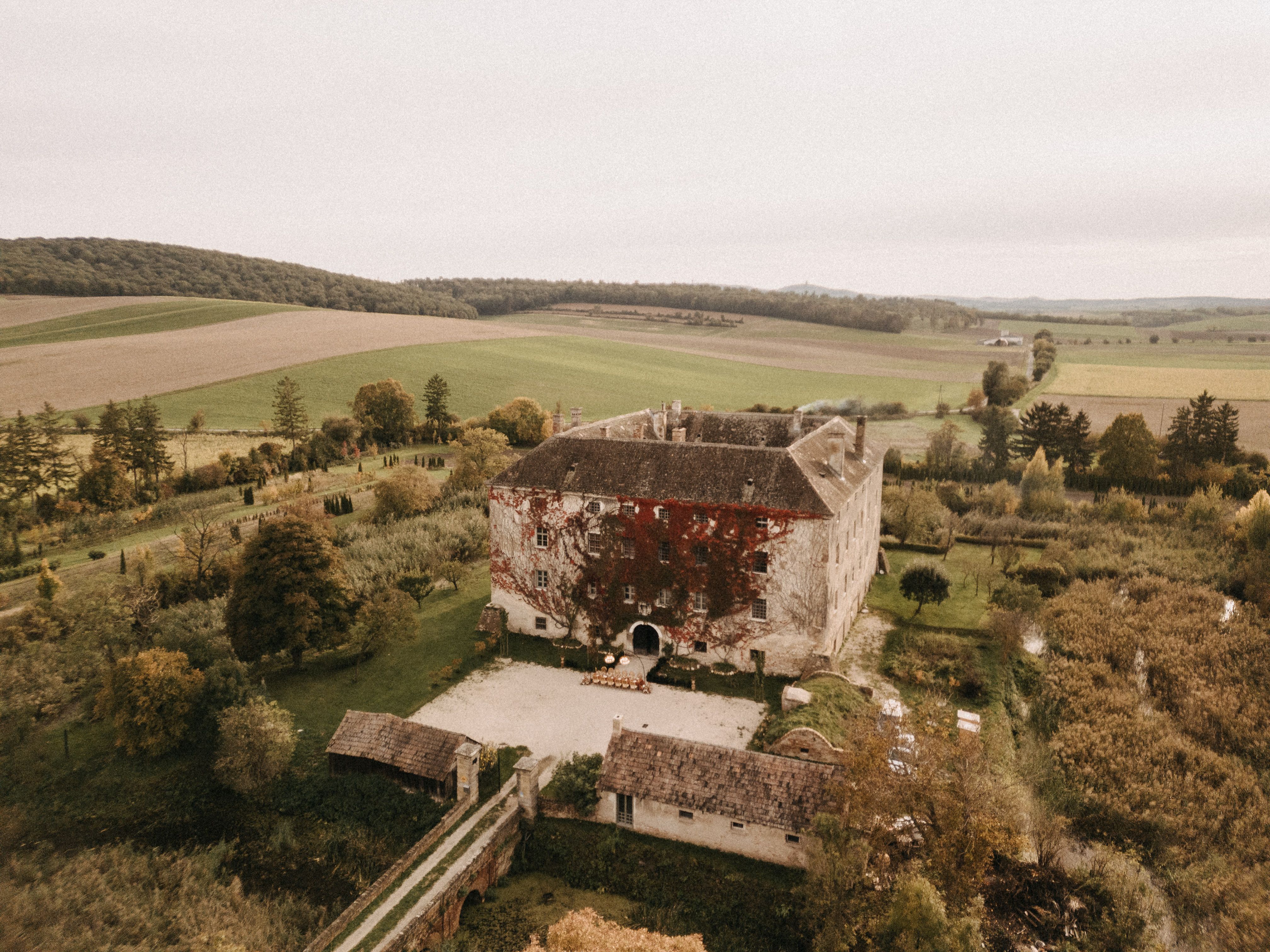 Luftaufnahme von Schloss Haggenberg umgeben von Feldern und Bäumen.