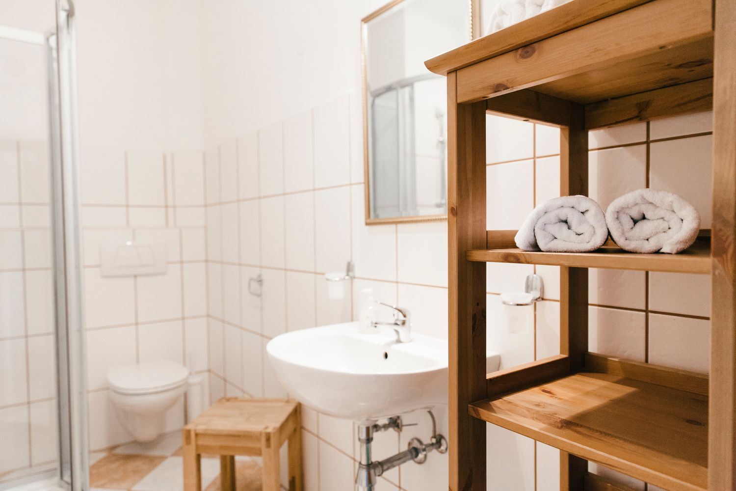 Modernes Badezimmer mit Waschbecken, Handtüchern und Dusche.