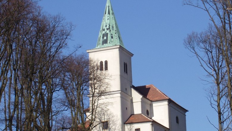 Wallfahrtskirche zur Heiligen Dreifaltigkeit auf einem Hügel, umgeben von Bäumen.