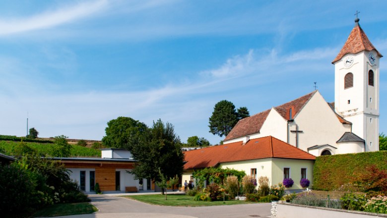Ein Winzerhof mit Kirche und Garten im Vordergrund.