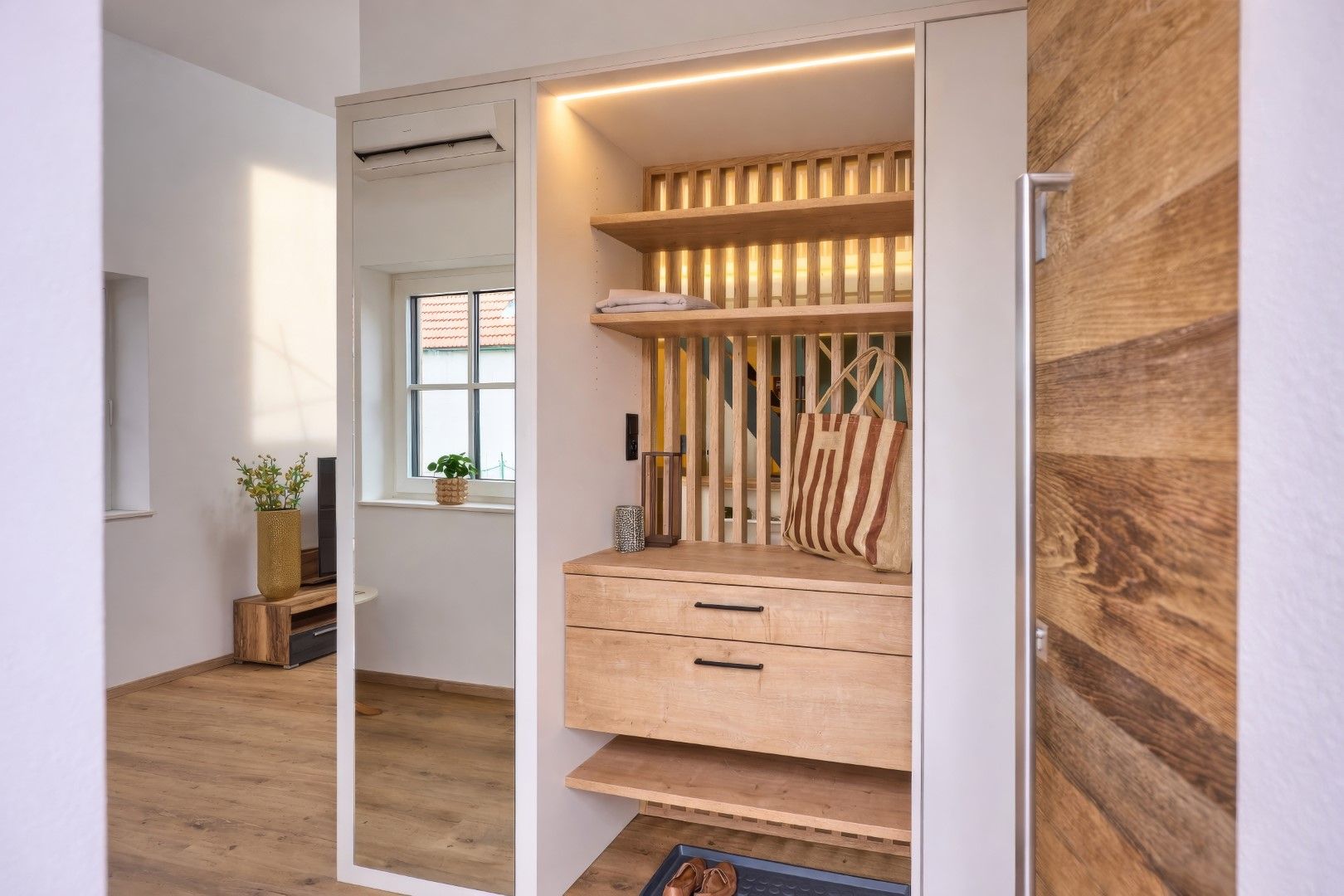 Moderner Eingangsbereich mit Holzdetails und Spiegel.