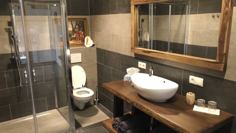 Modernes Badezimmer mit Dusche, Toilette und Waschbecken.