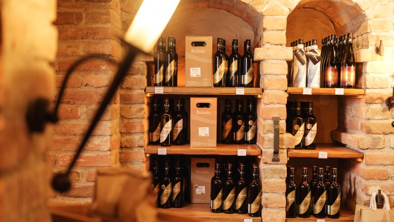 Wine bottles in a rustic cellar shelf made of bricks.