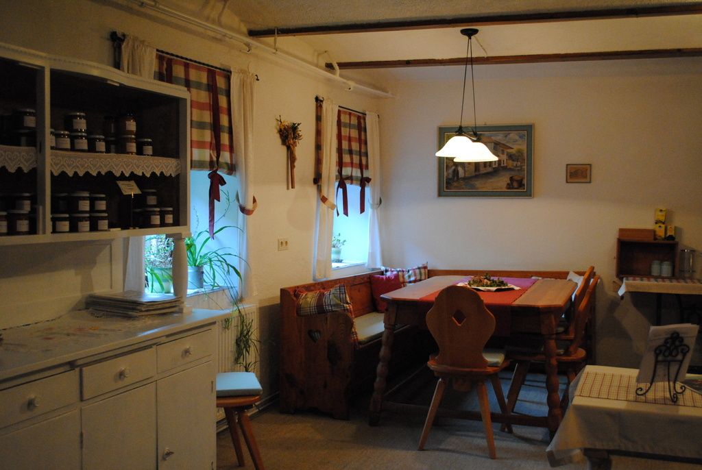 Gemütliche Küche mit Holzmöbeln und karierten Vorhängen.