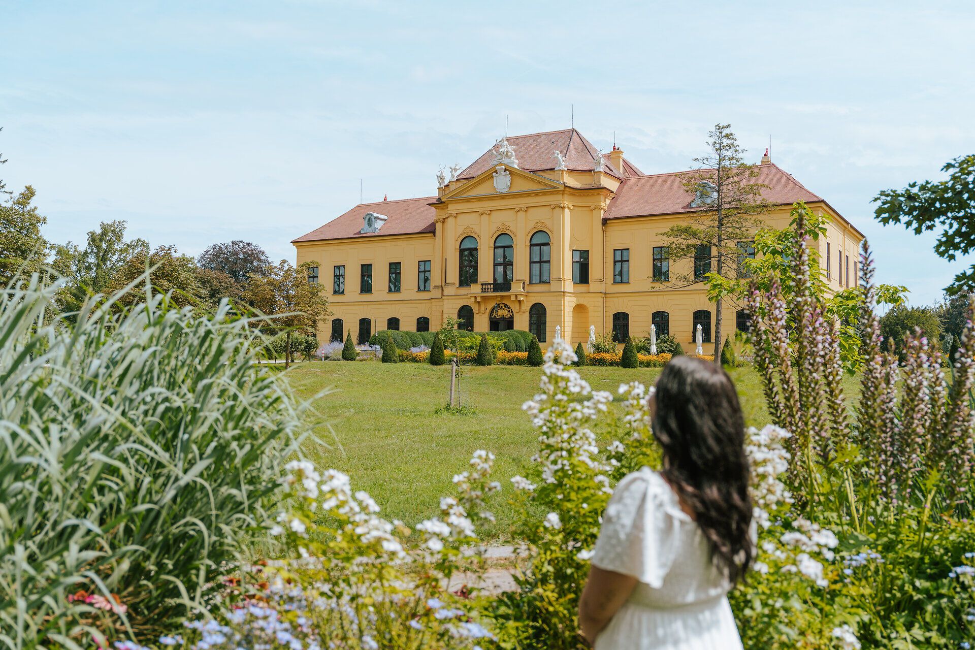 Umgeben von blühenden Blumen und üppigem Grün strahlt das Schloss eine einladende Atmosphäre aus. Der weitläufige Park lädt dazu ein, die Schönheit der Natur zu genießen und die Ruhe des Ortes zu erleben.