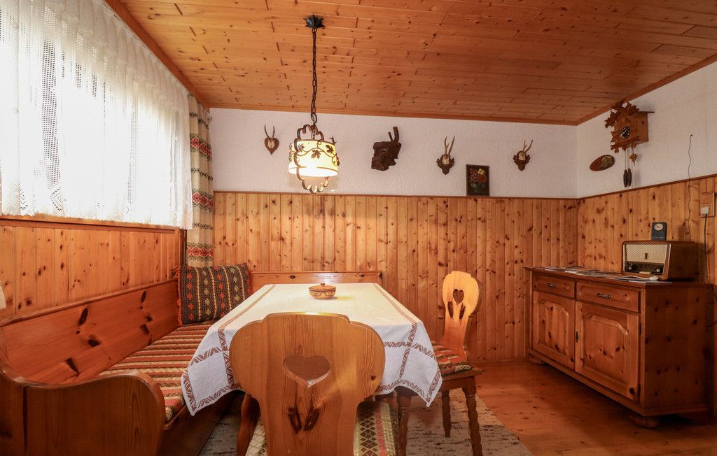 Gemütliches Kellerstüberl mit Holzmöbeln, Eckbank, Tisch, Radio und Jagdtrophäen an der Wand.