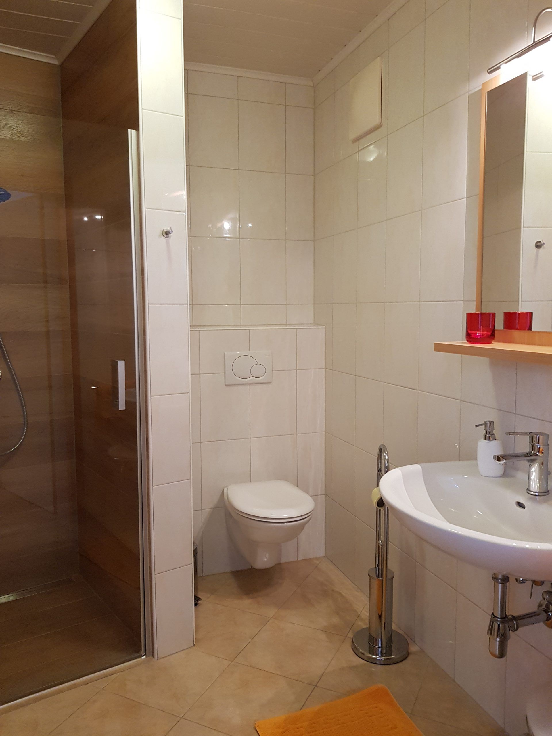 Modernes Badezimmer mit Dusche, Toilette und Waschbecken.