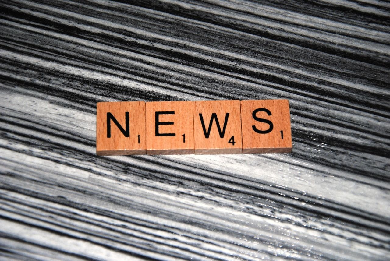 4 Holzbuchstaben formen das Wort News