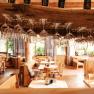 Interior view of a restaurant with hanging wine glasses and wooden furniture.